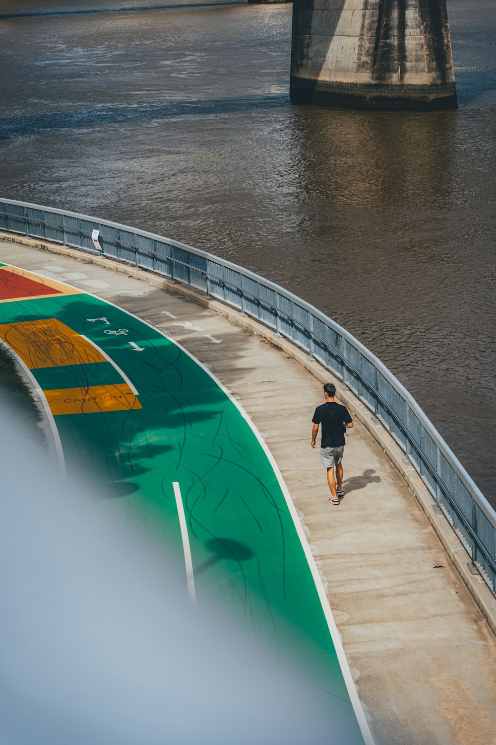 a man running on a bridge over a river