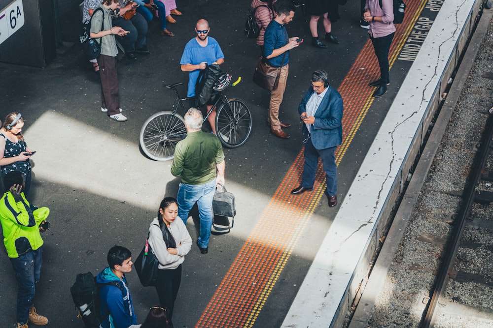 Un grupo de personas de pie alrededor de una estación de tren