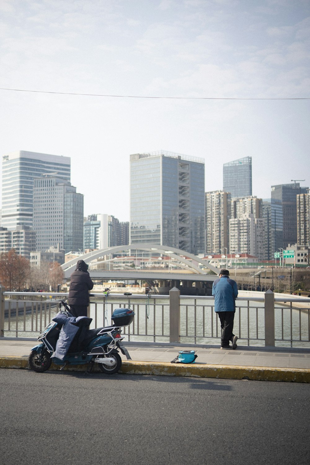 a man riding a motorcycle down a street next to a river