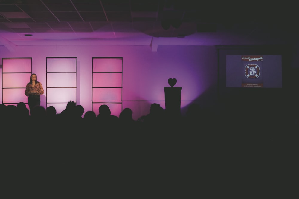 a woman standing on a stage in front of a crowd