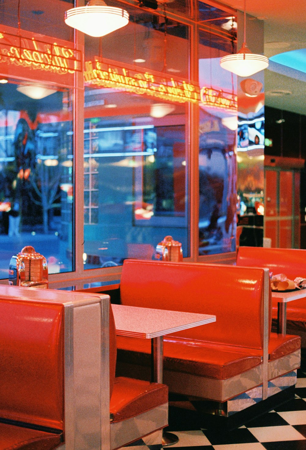 a restaurant with a checkered floor and red booths