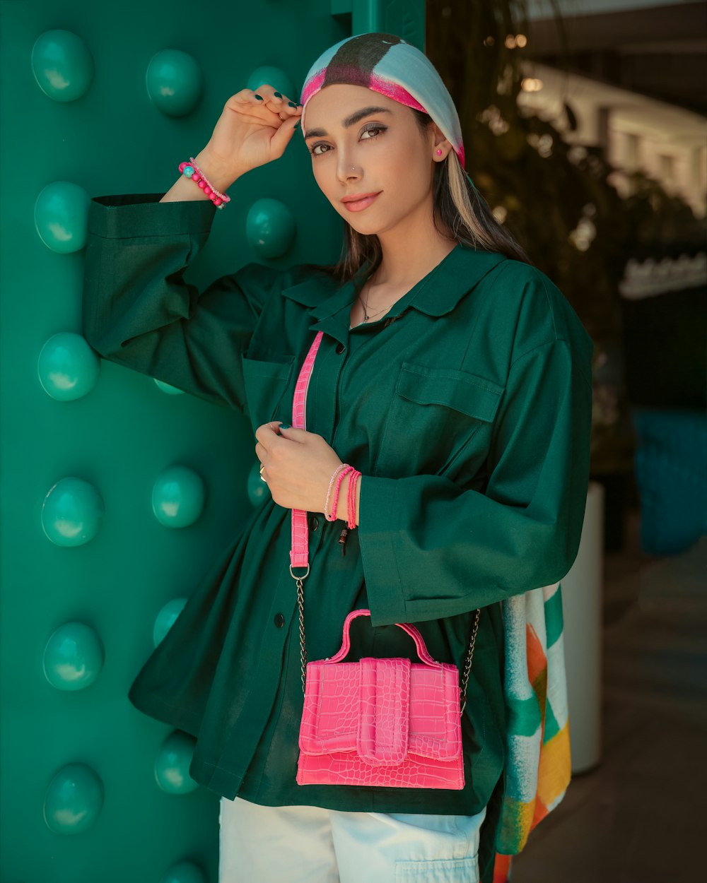 a woman in a green shirt holding a pink purse