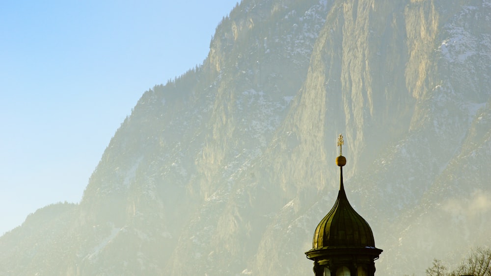 a church steeple with a mountain in the background