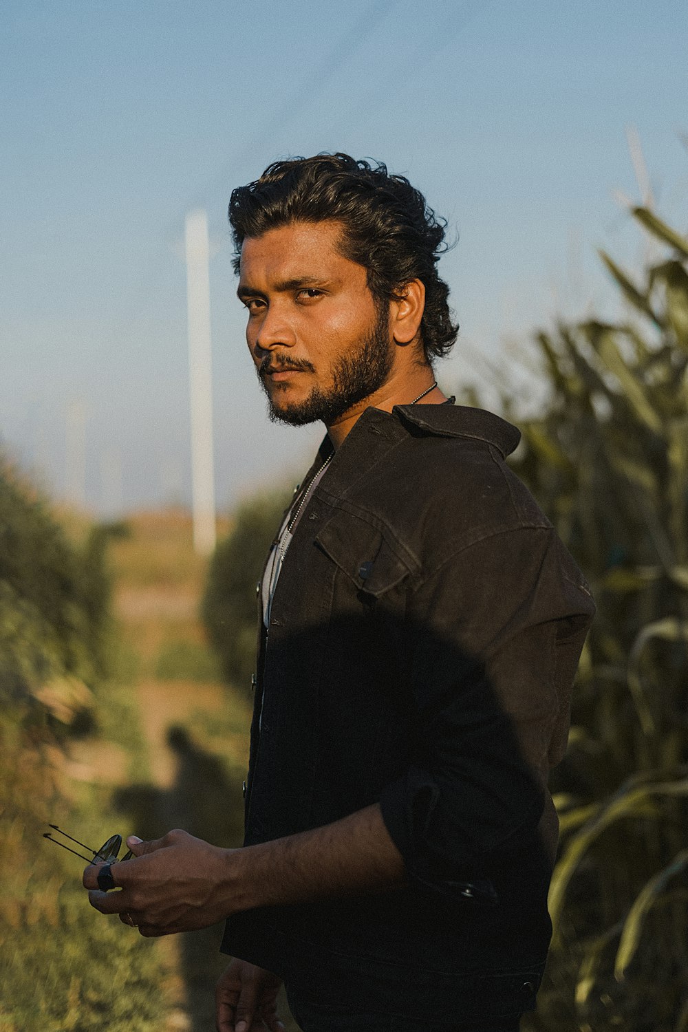 a man standing in front of a corn field