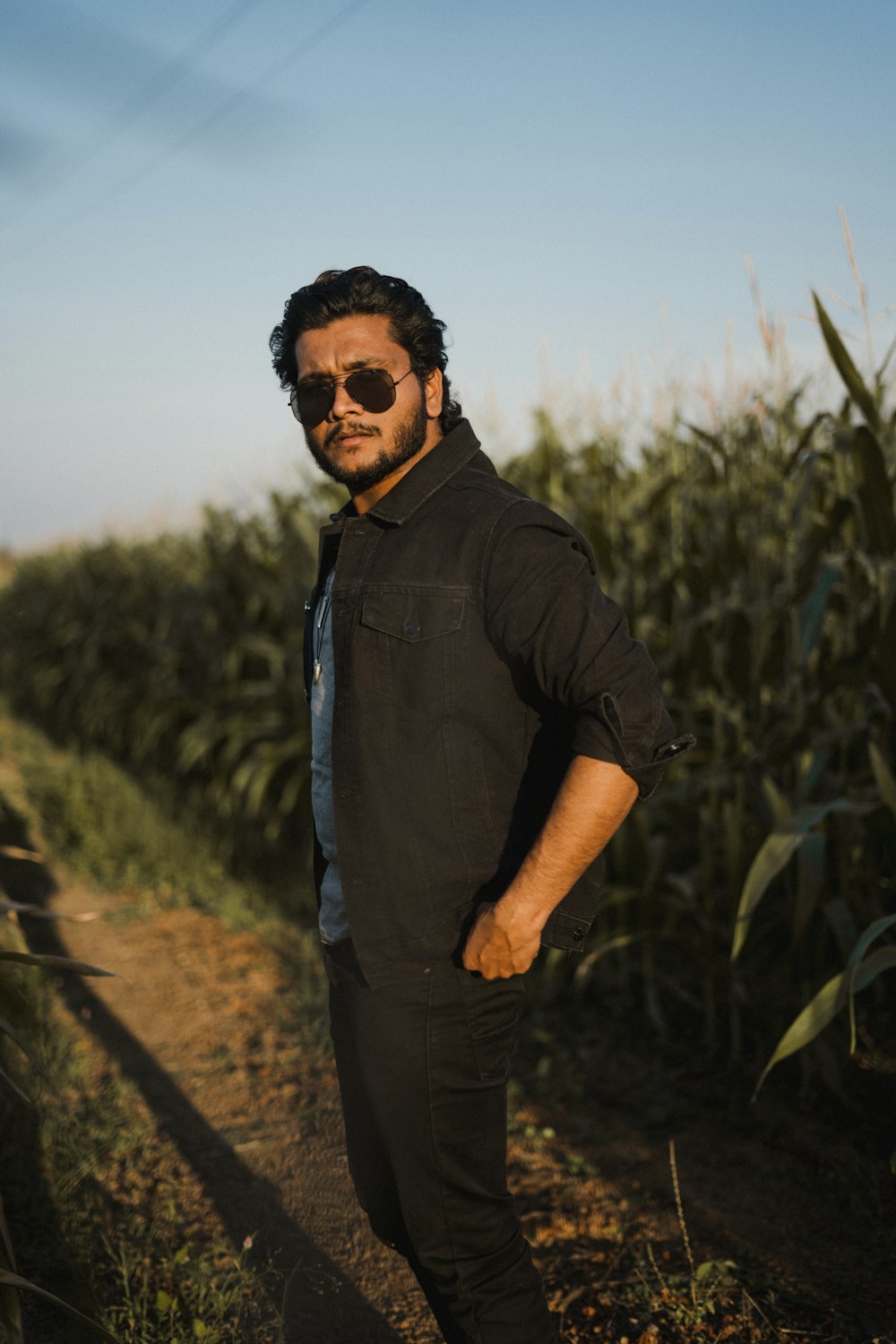 a man standing in front of a field of corn