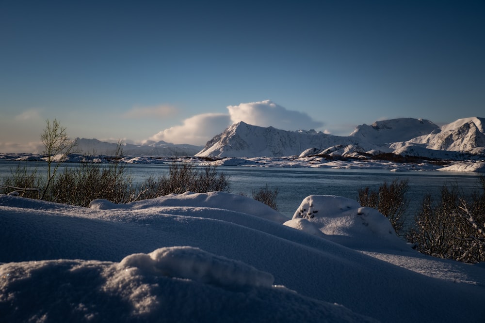 a snow covered landscape with mountains in the background