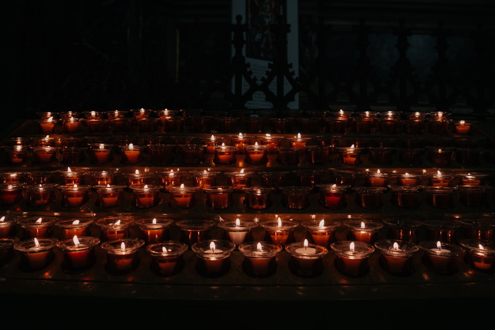 a bunch of lit candles sitting on a table