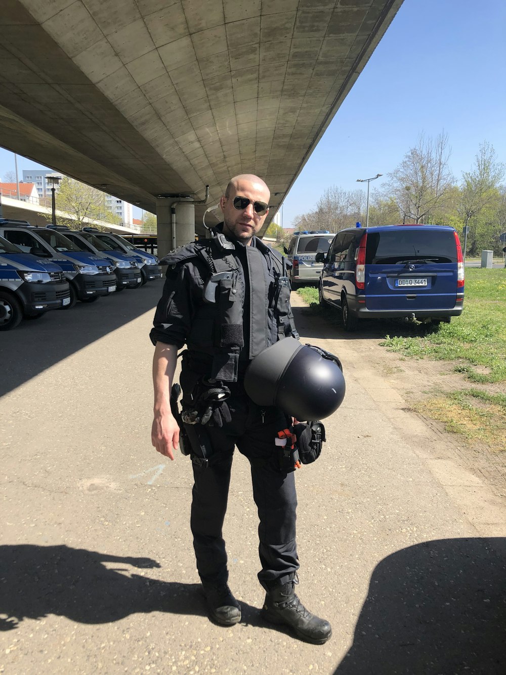 a man with a helmet and goggles standing in a parking lot