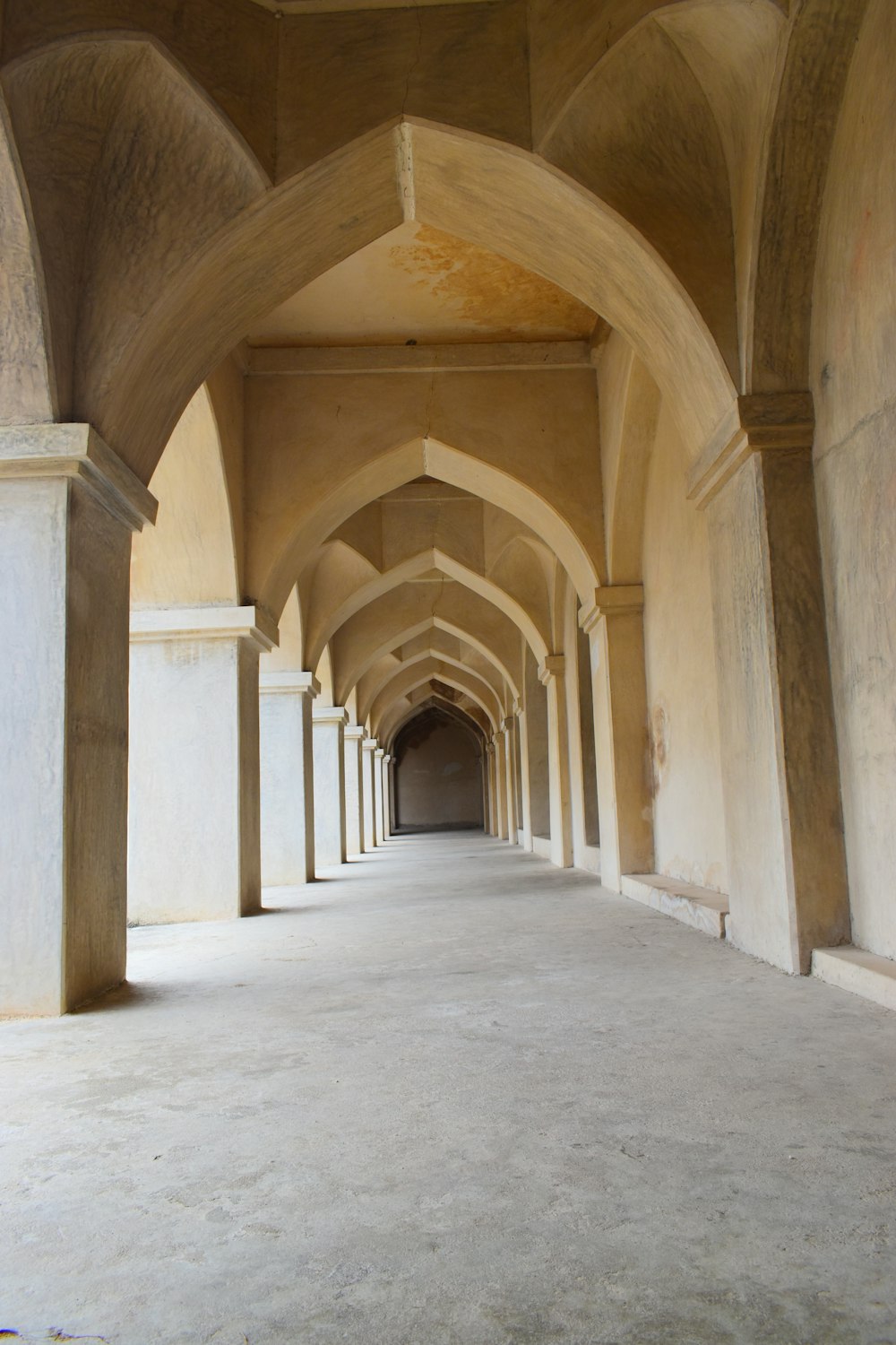 a long hallway with arches and pillars in a building