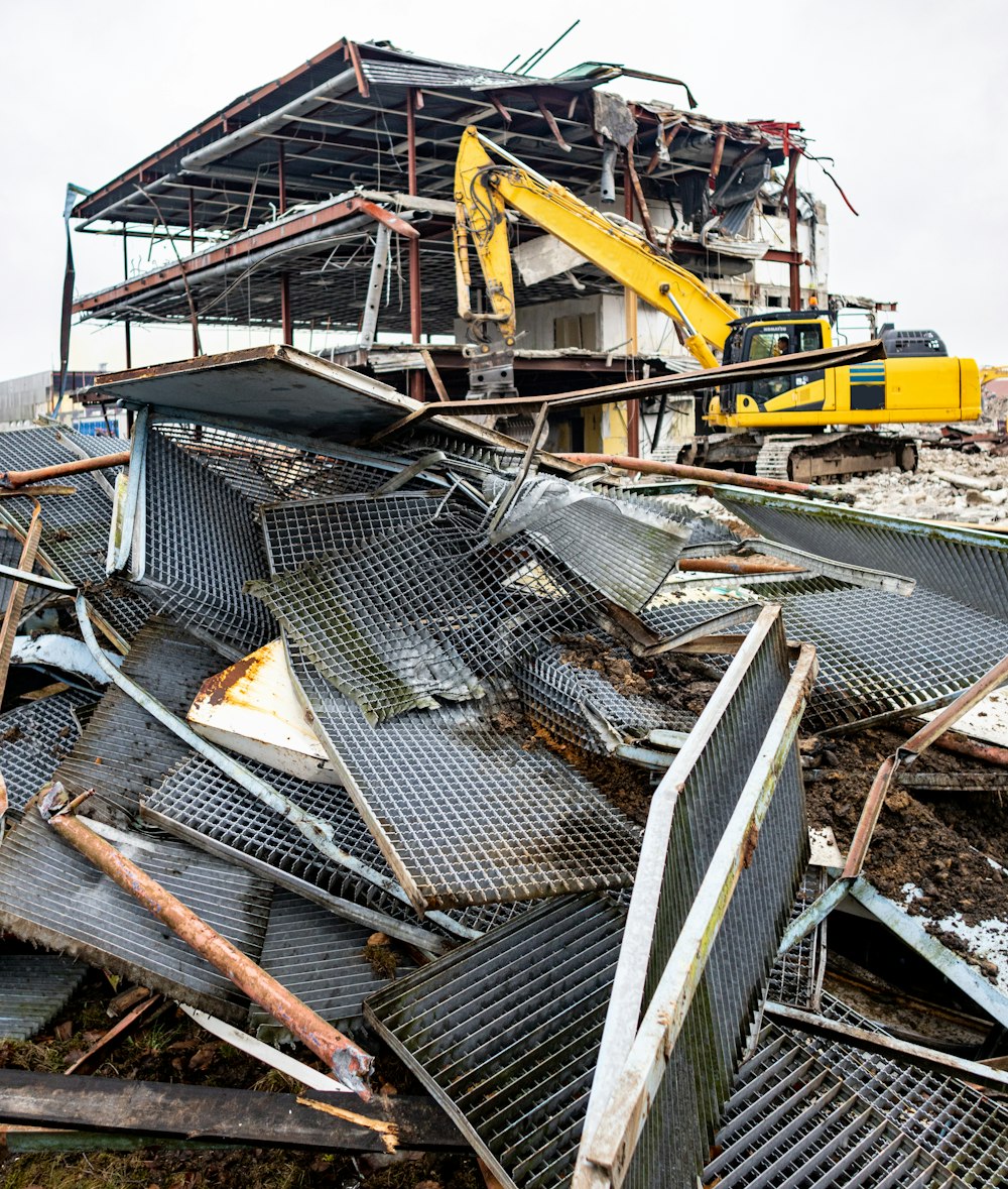 a pile of rubble with a yellow bulldozer in the background