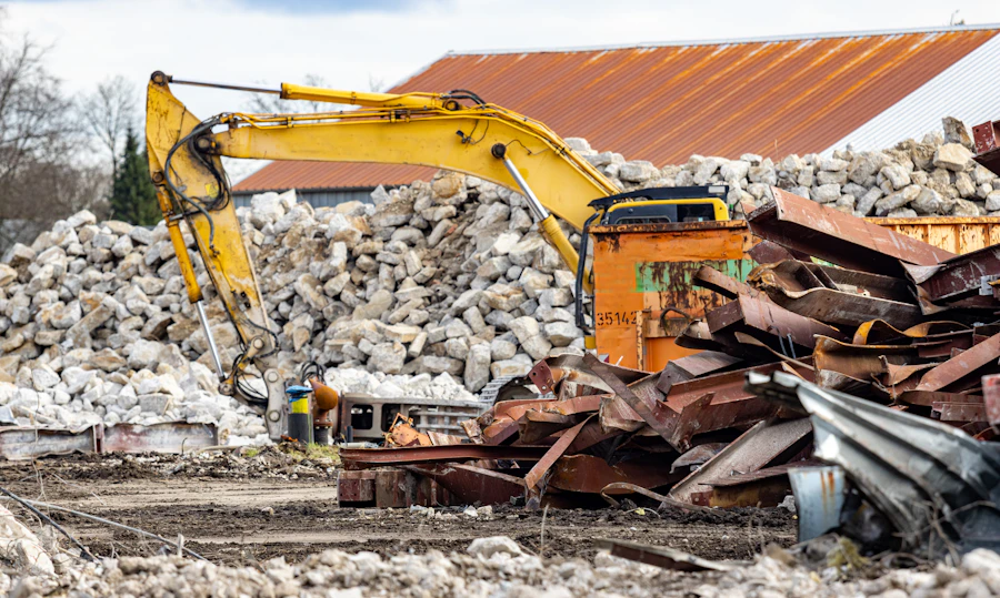 Excavator beside piles of concrete rubble and scrap metal on a demolition site