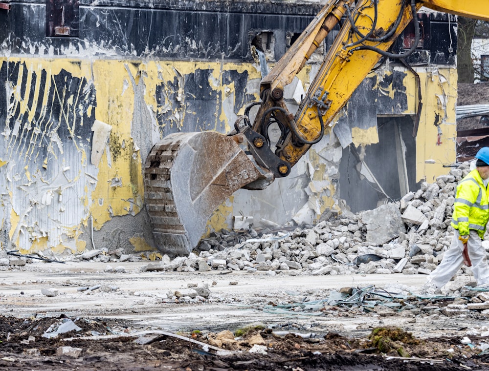 a man in a yellow jacket and a yellow bulldozer