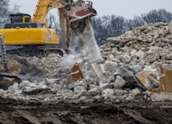 a bulldozer digging through a pile of rubble