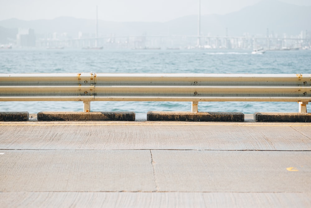 a bench sitting on the side of a road next to the ocean