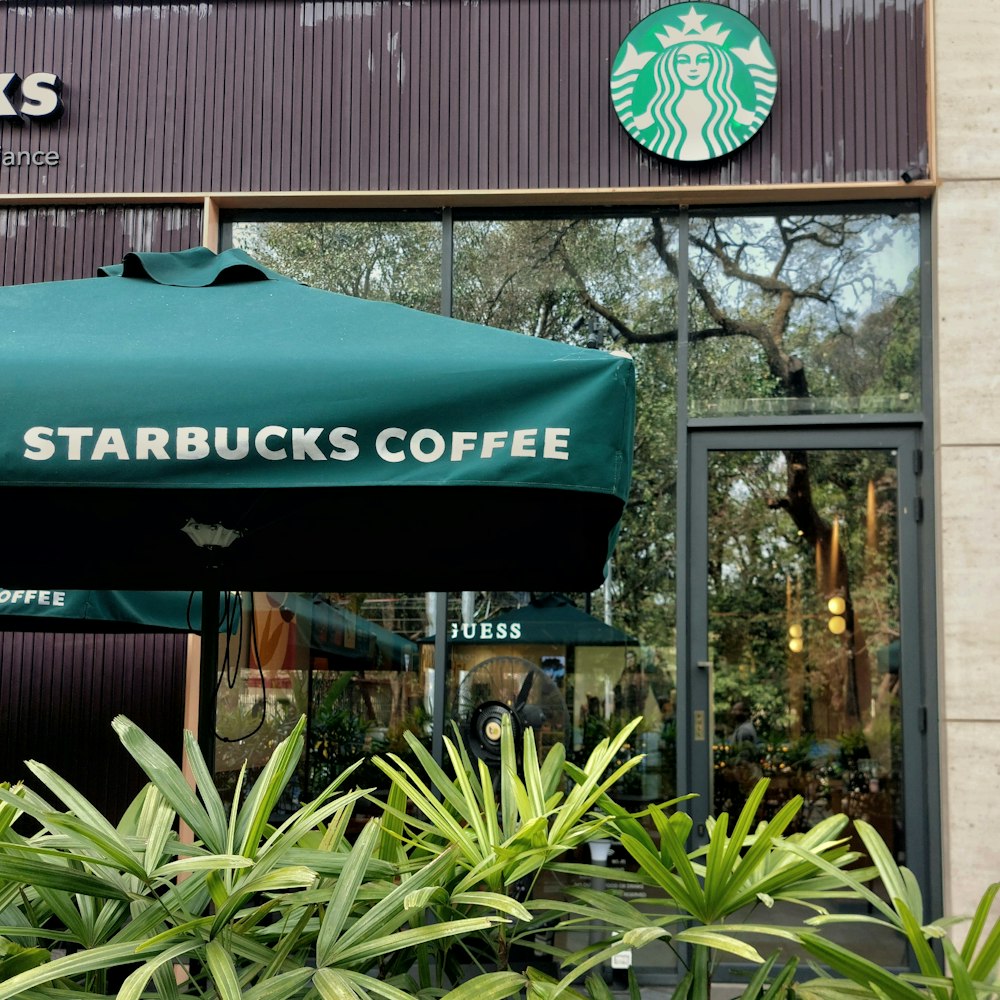 a starbucks coffee shop with a green umbrella