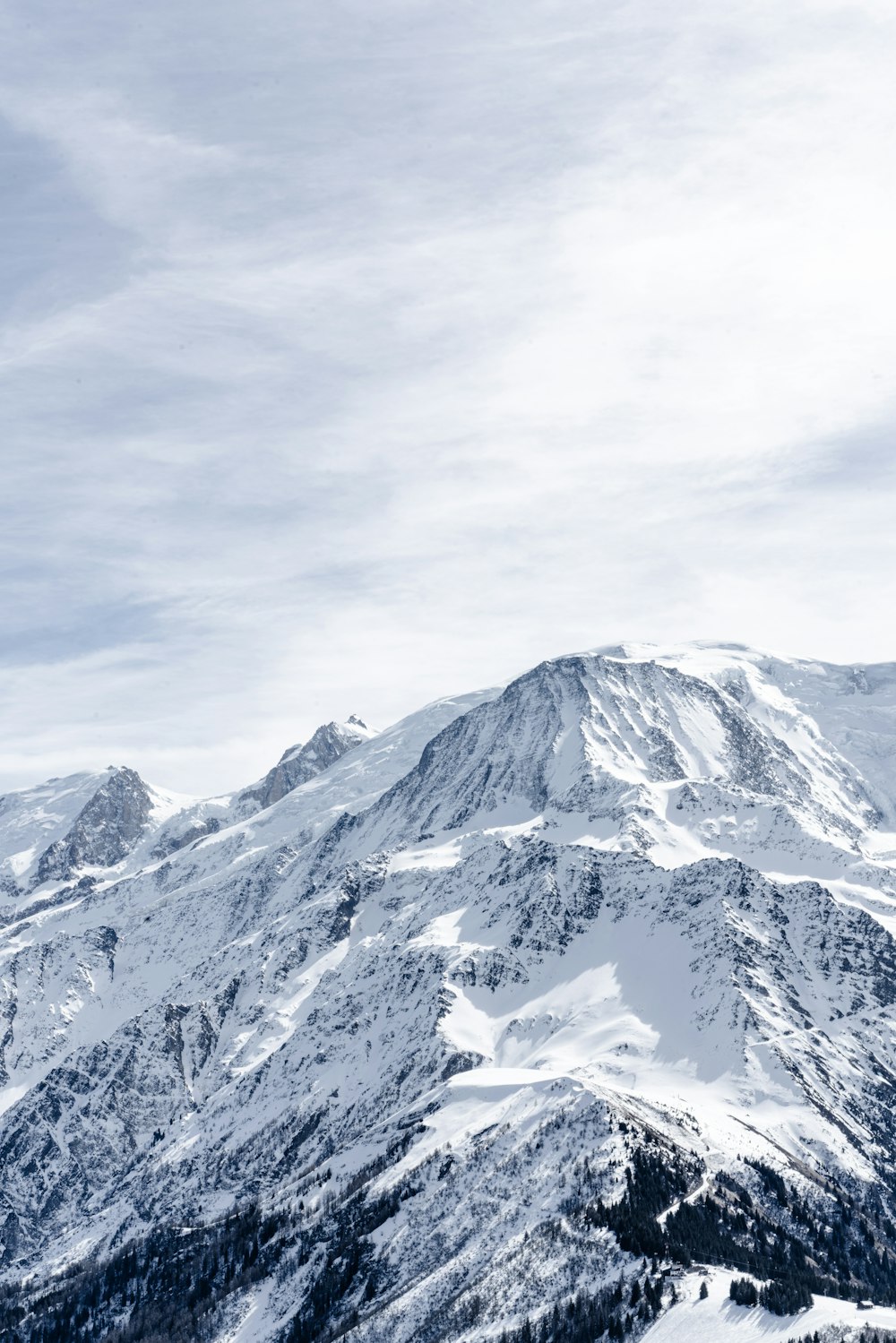 a snow covered mountain with a snowboarder on top of it