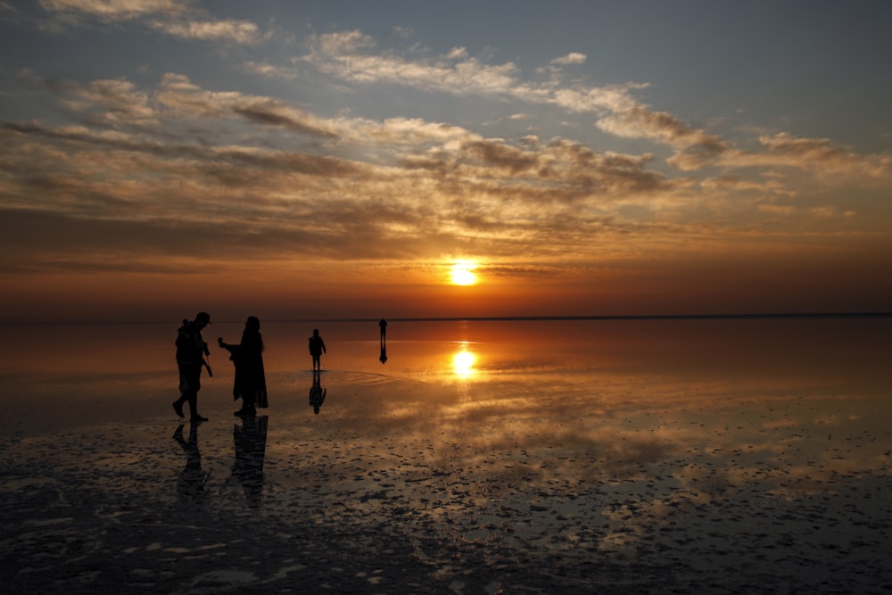 a group of people standing on top of a beach