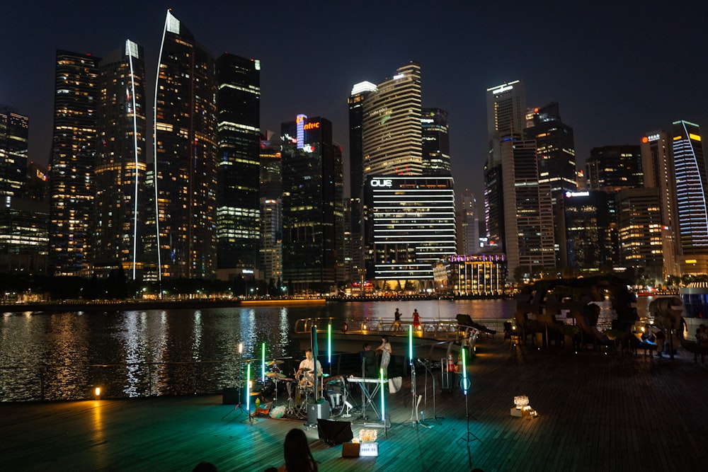a night scene of a city skyline with a boat docked in the foreground
