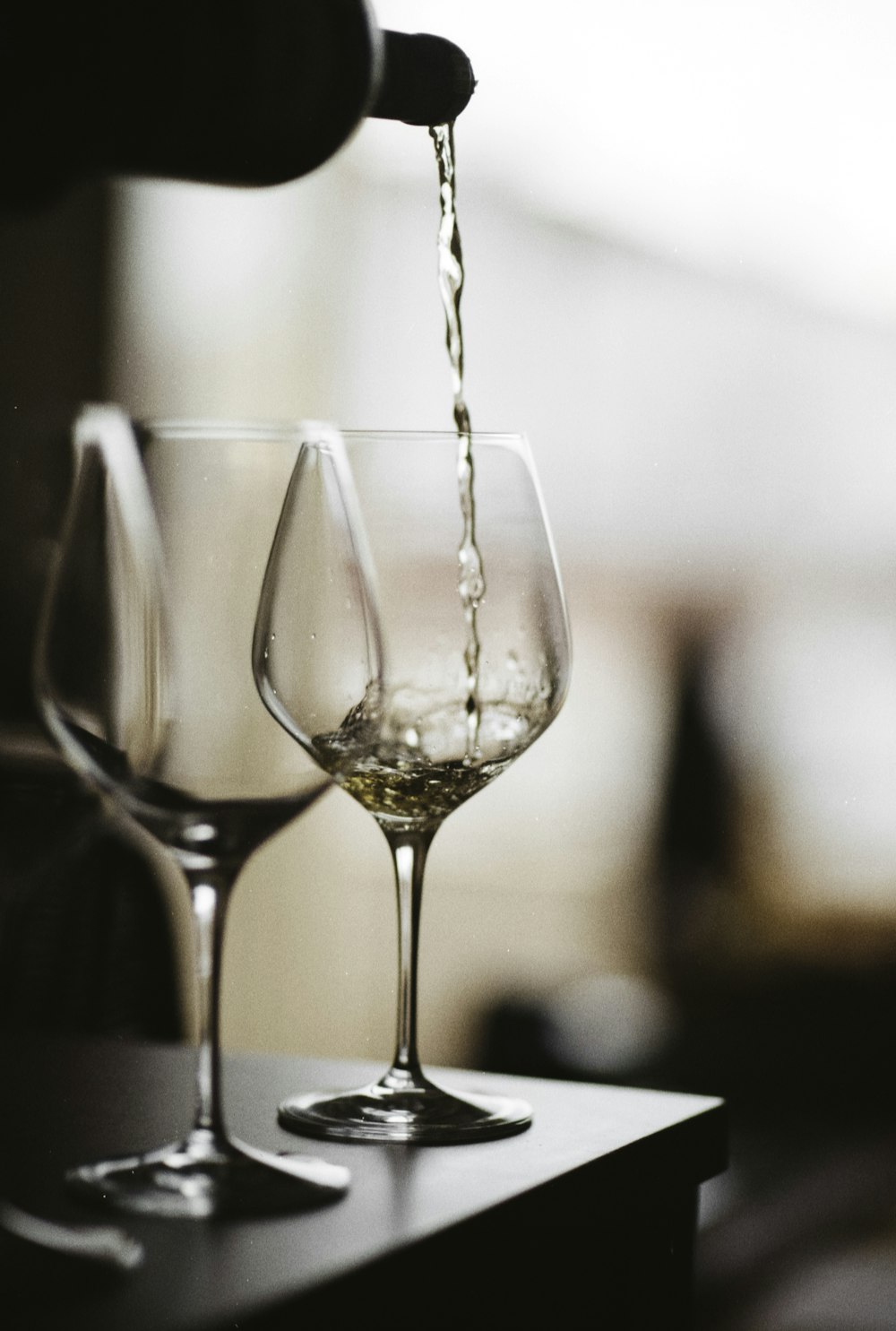 a person pouring wine into a wine glass