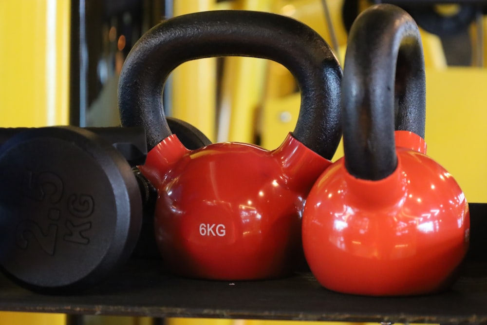 a couple of red kettles sitting on top of a shelf