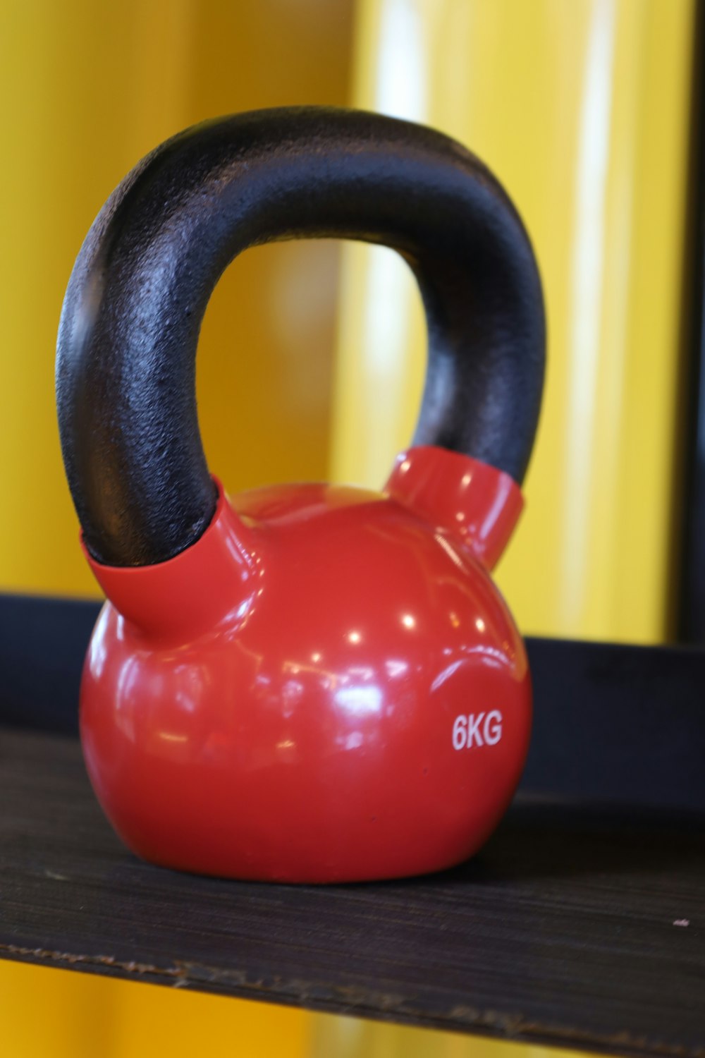 a red kettle sitting on top of a wooden shelf