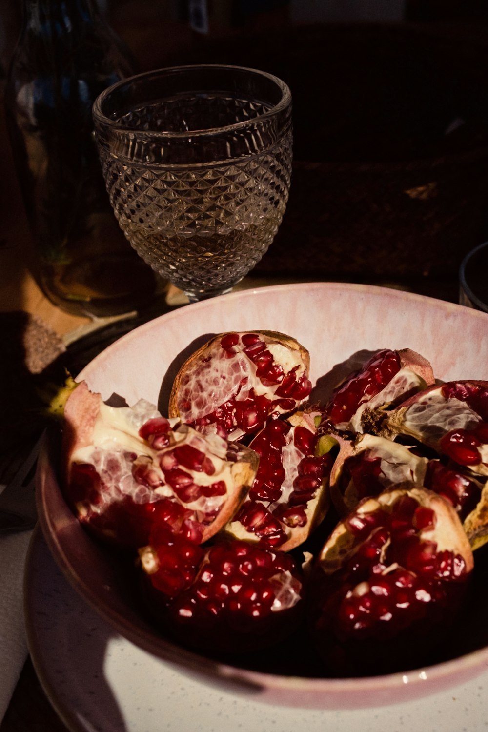 a bowl of pomegranates on a table
