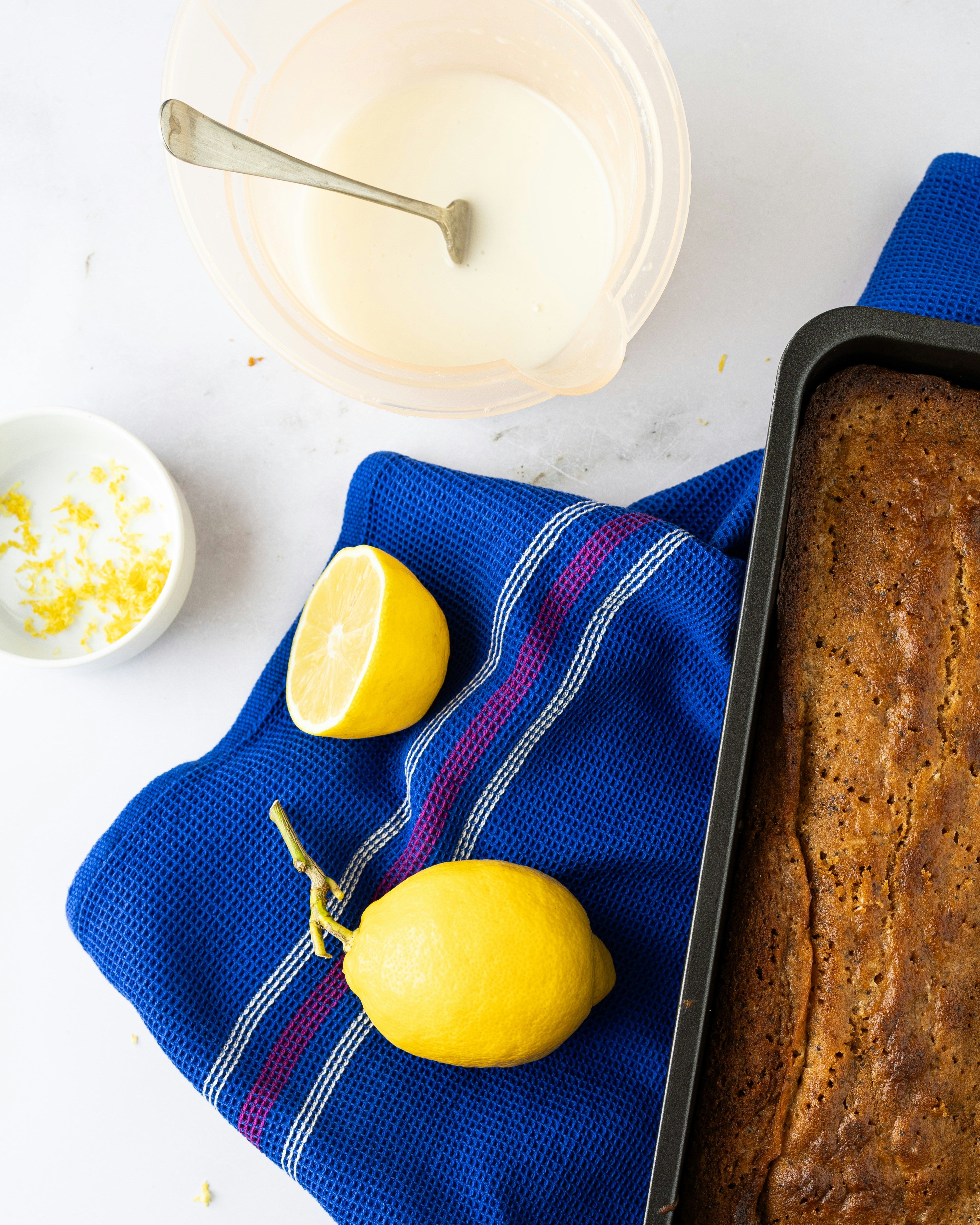 a loaf of bread and two lemons on a blue towel