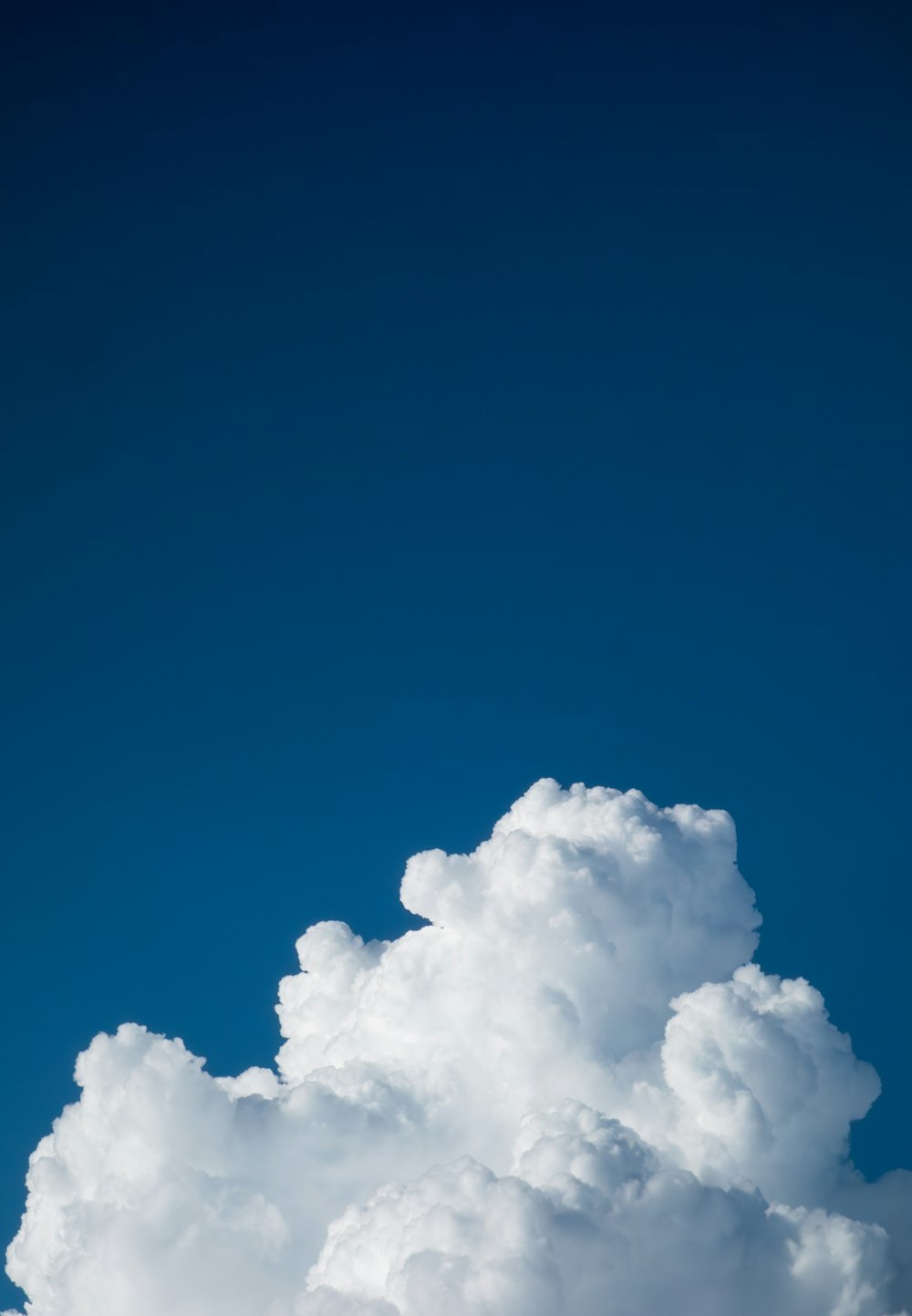 a plane flying through a cloud filled sky