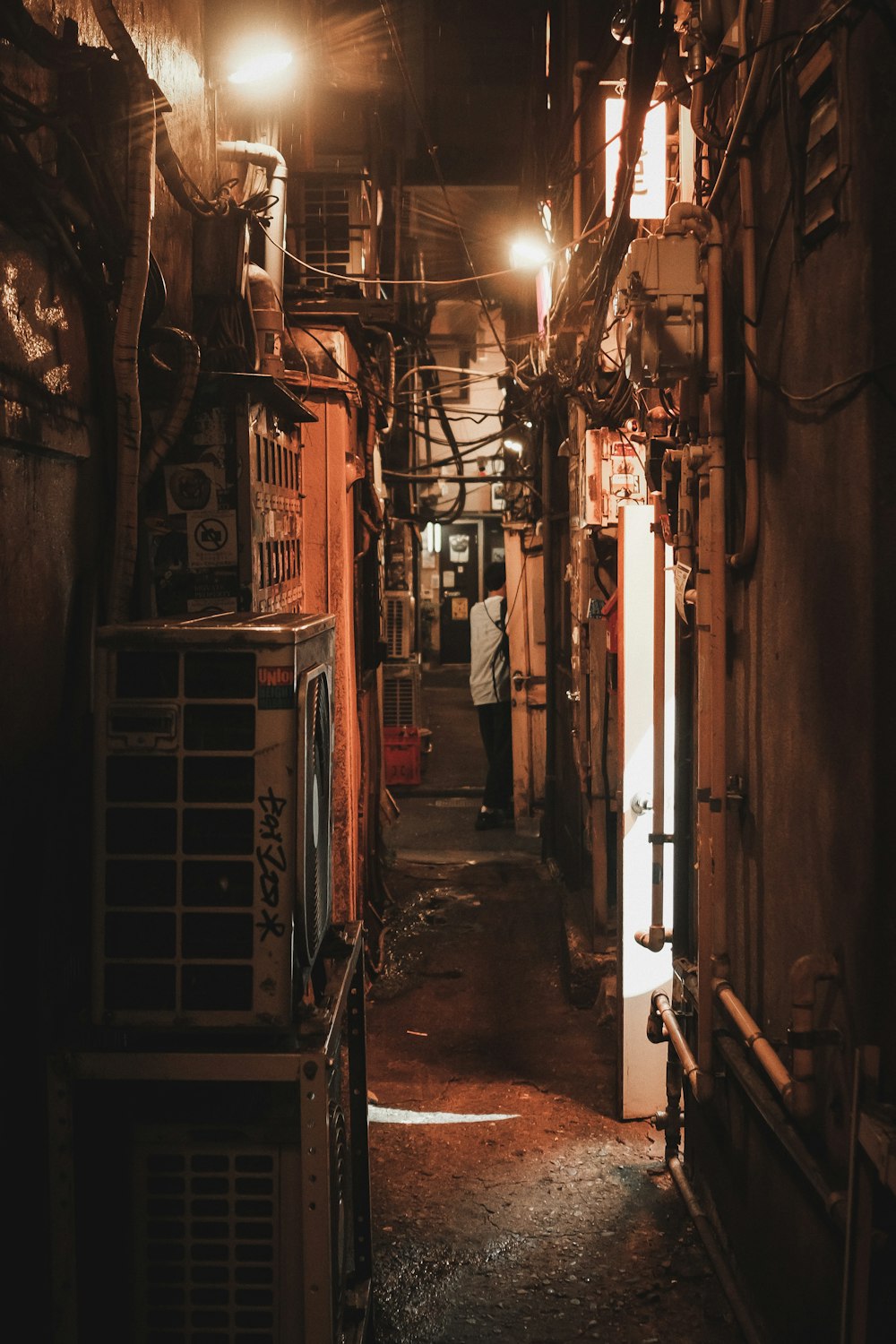 a narrow alley way with a person standing in the doorway