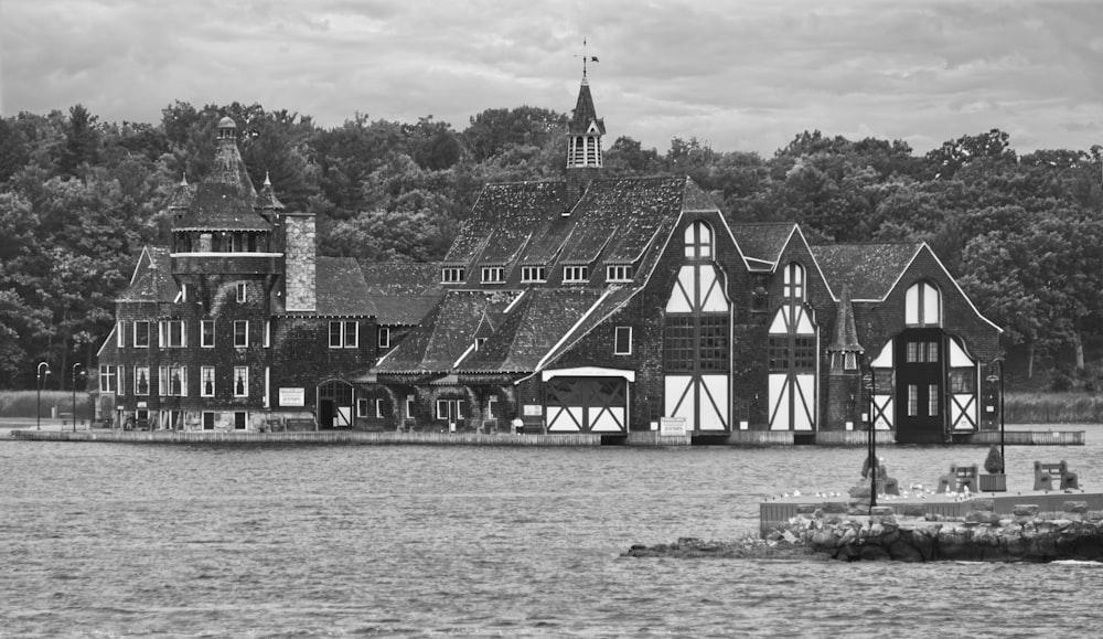 a black and white photo of a house on the water
