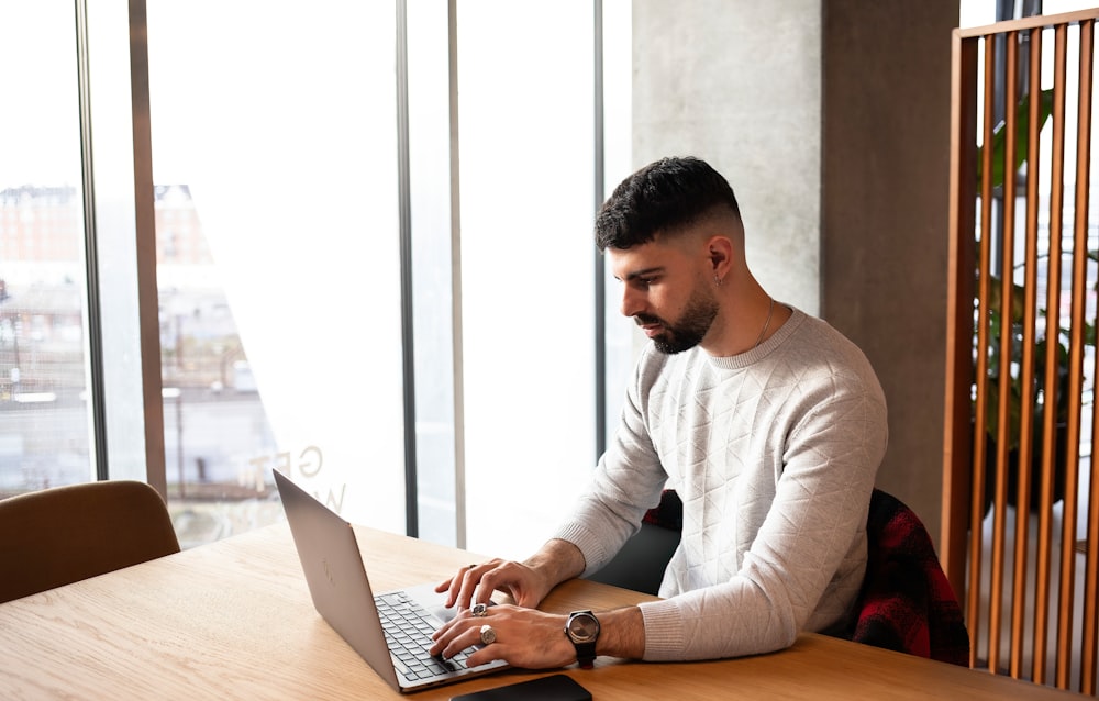 a man sitting at a table using a laptop computer