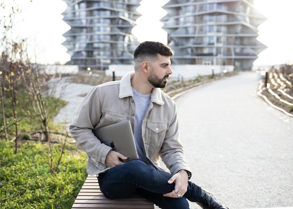 a man sitting on a bench with a laptop