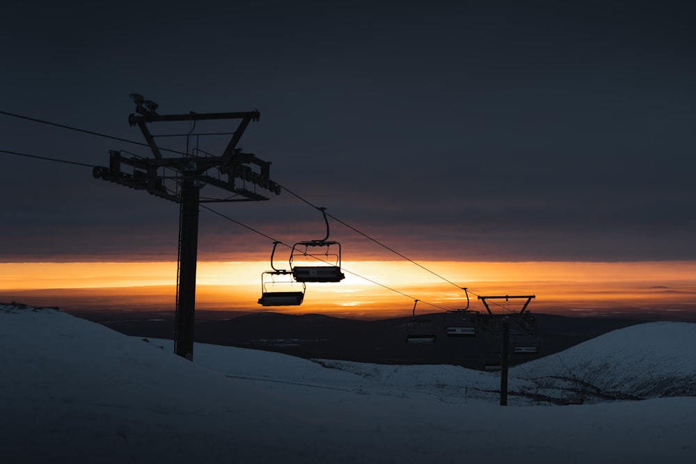 a ski lift with a sunset in the background