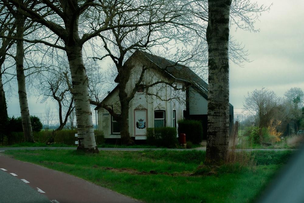 a small white house sitting next to a tree