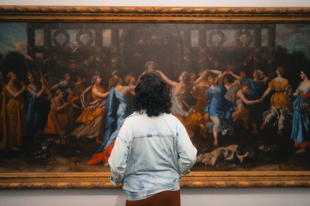 a woman looking at a painting in a museum