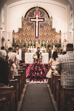 a woman in a red dress sitting in a church
