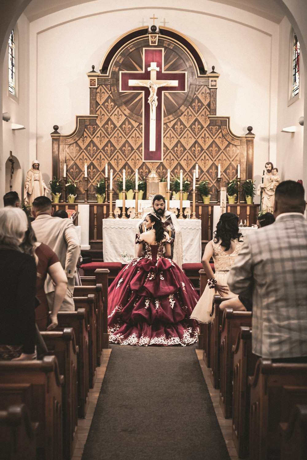 a woman in a red dress sitting in a church