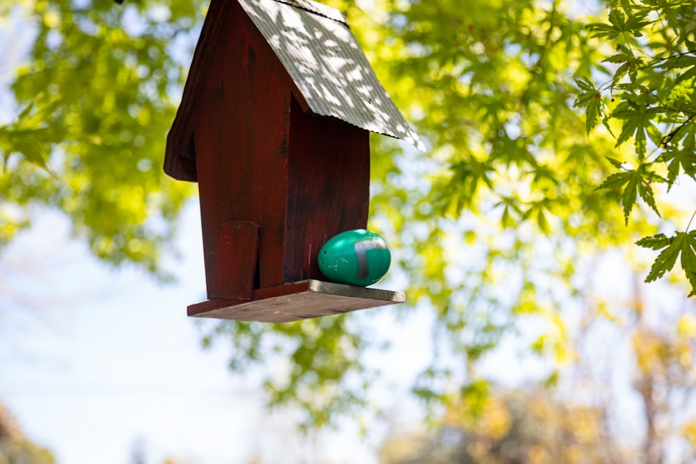 a birdhouse with a green ball on the top of it