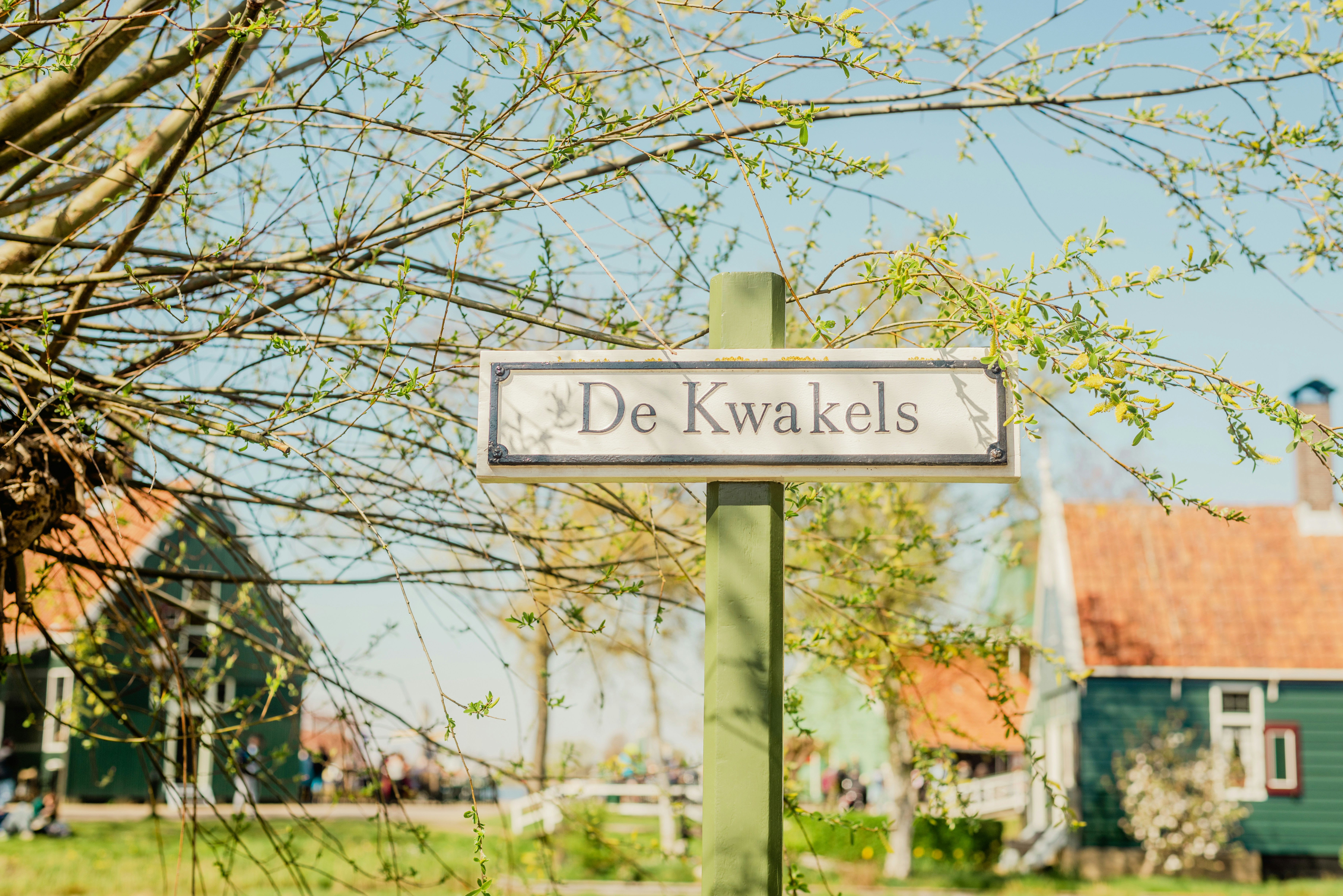 a street sign in front of a green house