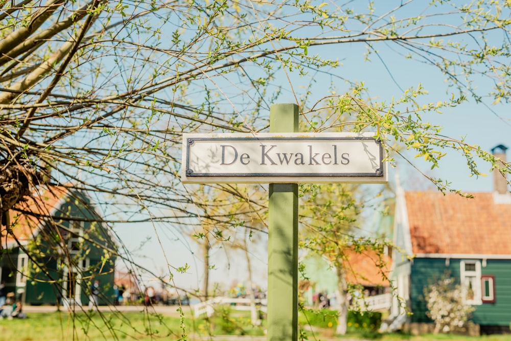 a street sign in front of a green house