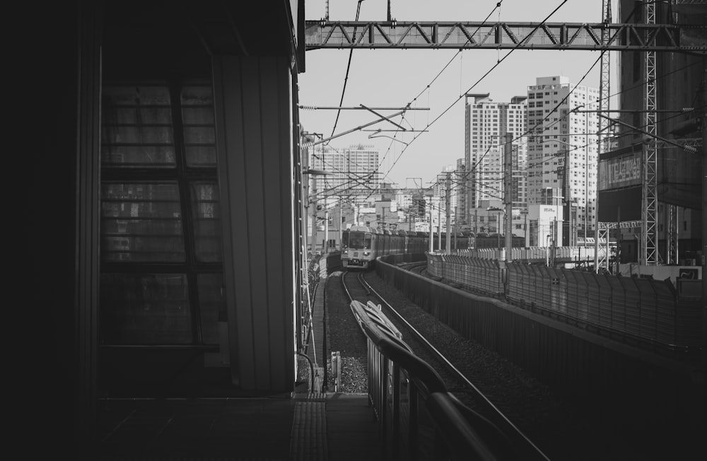 a black and white photo of a train coming down the tracks