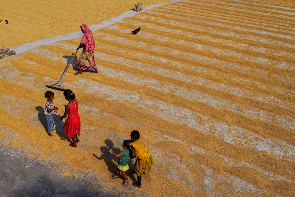 a group of people standing on top of a sandy beach