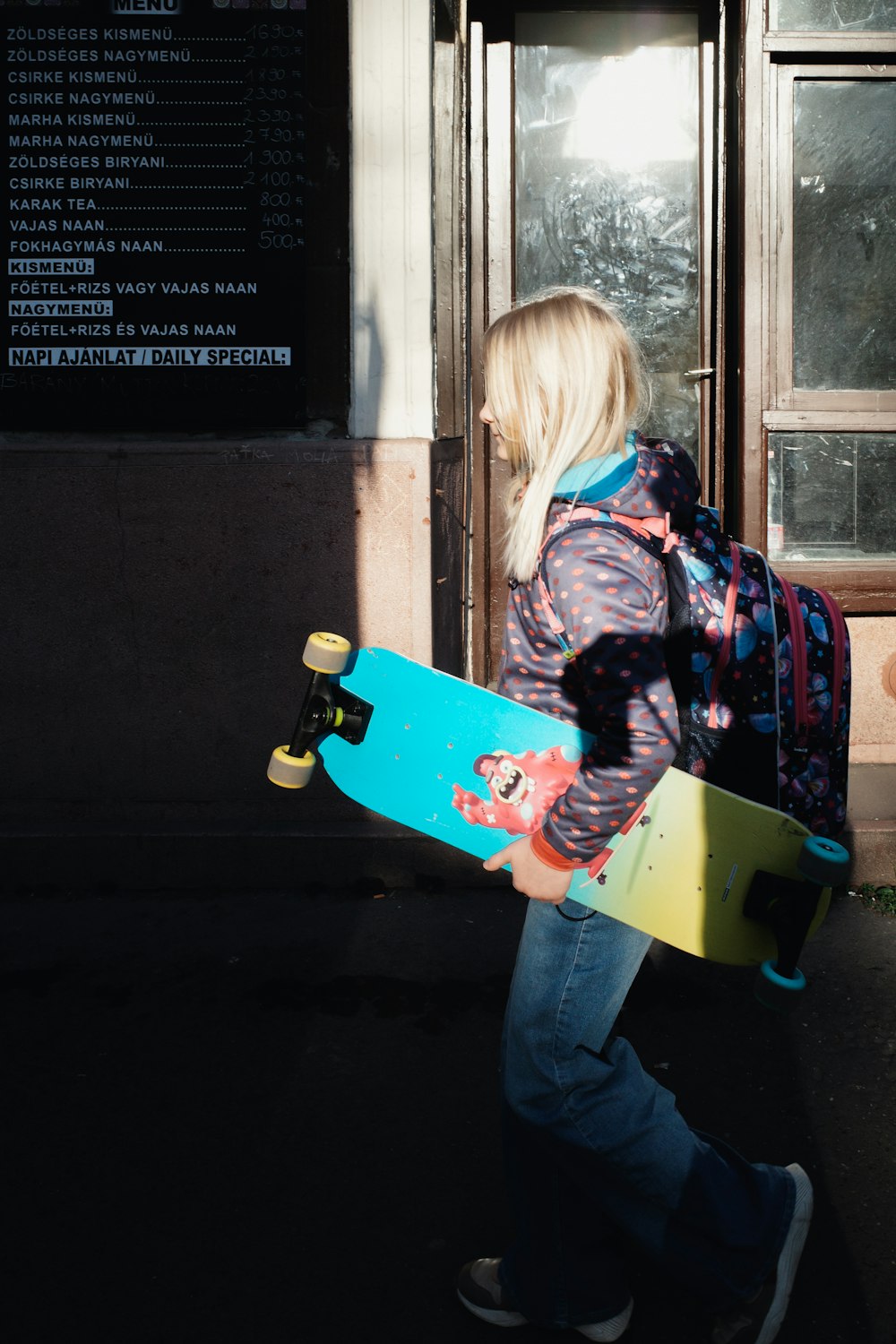 a person walking with a skateboard in their hand