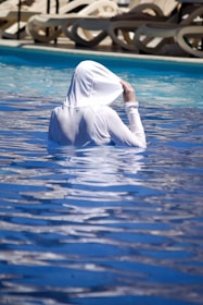a woman in a white outfit is in a pool