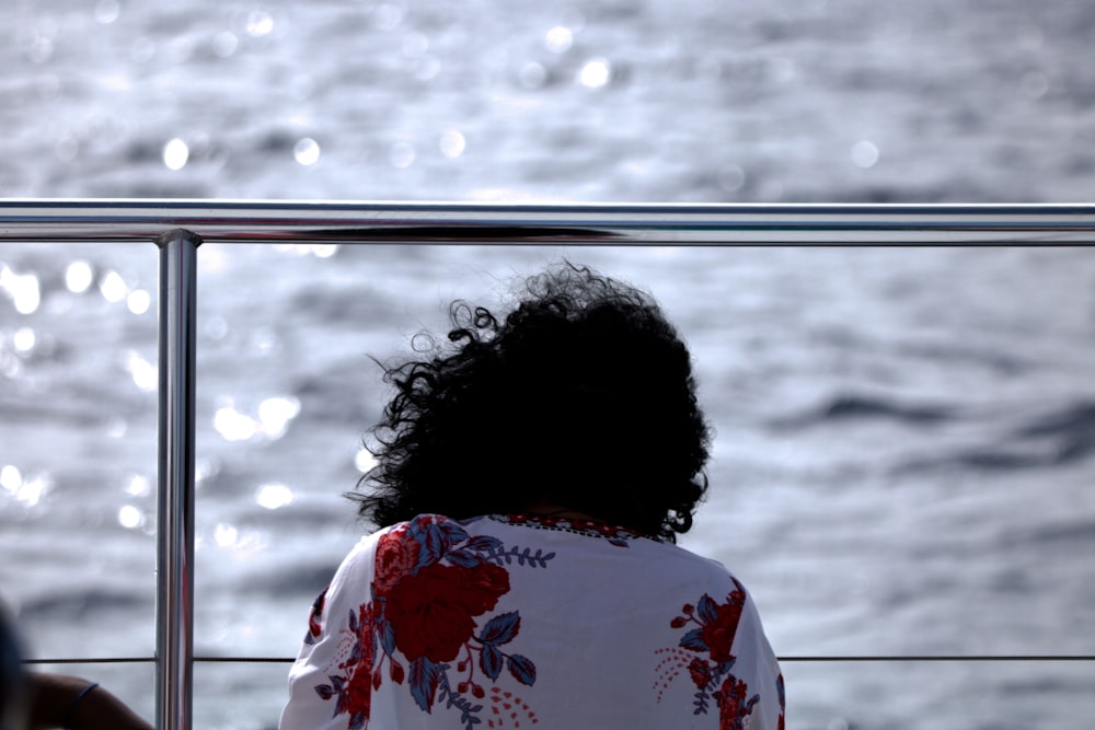 a woman sitting on a boat looking out at the ocean