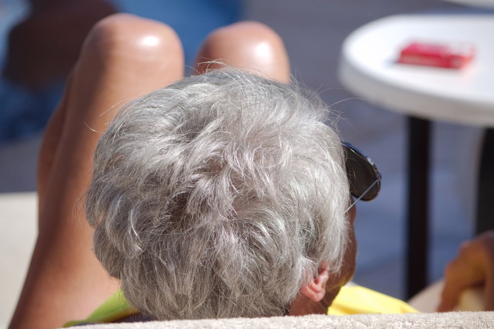 a man with grey hair and sunglasses sitting in a chair