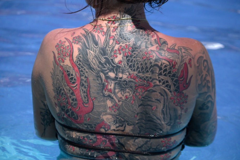 eine Frau mit einem Drachen-Tattoo auf dem Rücken