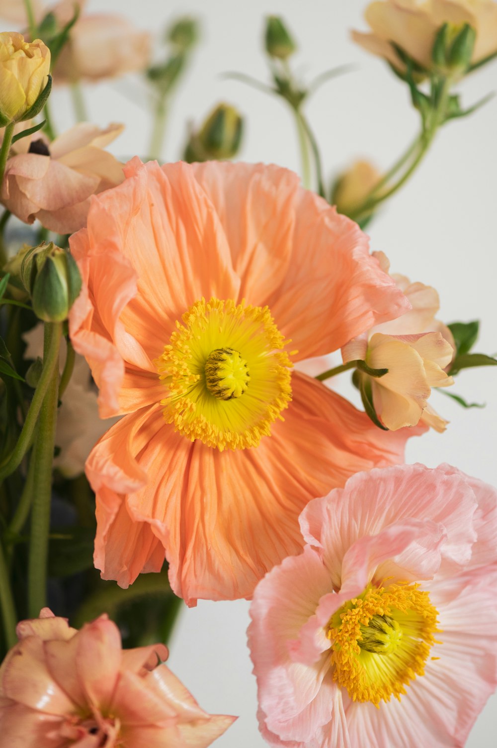 a vase filled with pink and yellow flowers