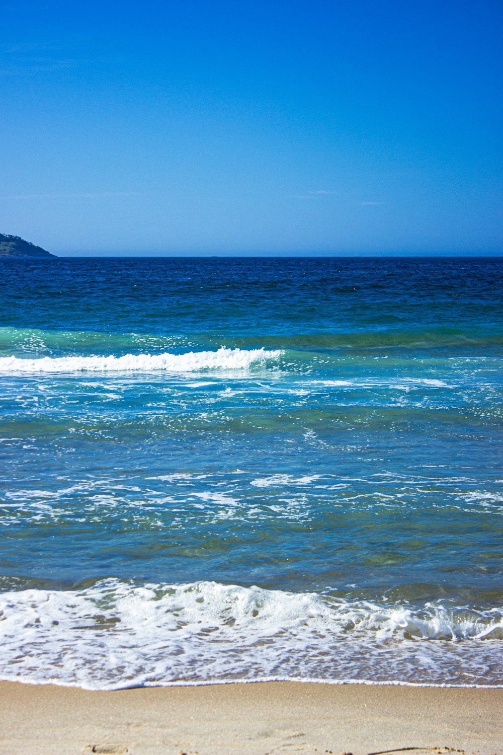 a person walking on the beach with a surfboard