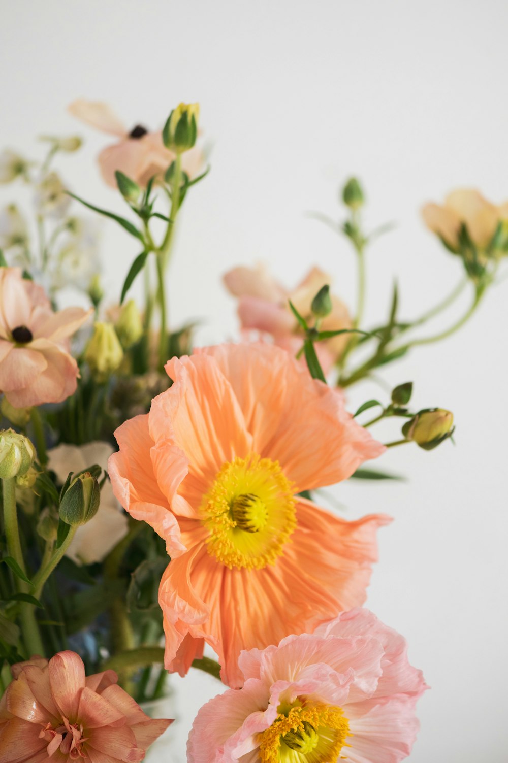 a vase filled with pink and yellow flowers